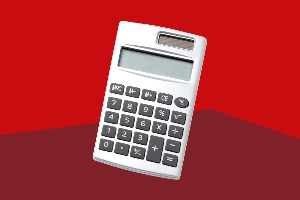 Ein silberner Taschenrechner vor rotem Hintergrund.